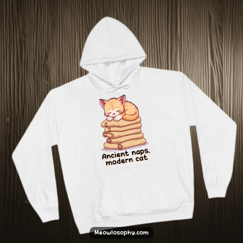 Funny sleepy kitten hoodie, depicting a wise cat curled up asleep on a stack of ancient scrolls, offering warmth and humor.