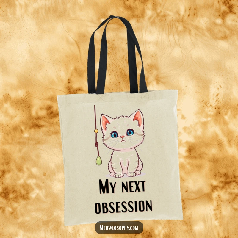 Funny curious kitten tote bag, showing a thoughtful cat batting a playful dangling string, a stylish and humorous accessory.